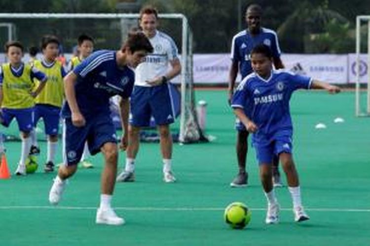 Pemain Chelsea, Lucas Piazon dan Ramires (belakang) memberikan sesi coaching clinic di Lapangan Hoki, Senayan, Rabu (24/7/2013). Chelsea akan bertanding melawan Indonesia All Star pada Kamis, 25 Juli 2013.