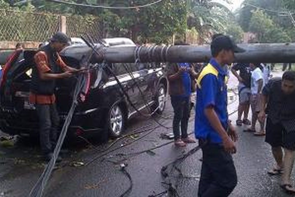Satu unit mobil tertimpa tiang listrik di Kebagusan, Jakarta, Jumat (25/10/2013)