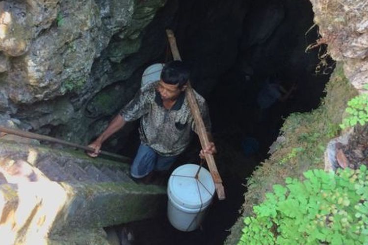 Seorang warga Desa Klepu, Pacitan, mengambil air bersih dari gua vertikal karena rumahnya belum mendapat pasokan air bersih PDAM. 