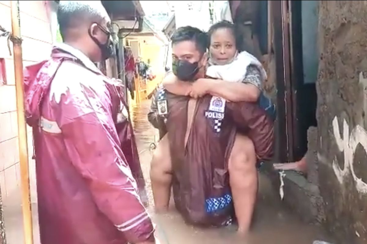 Kapolsek Cilandak Kompol Iskandarsyah mengevakuasi nenek-nenek banjir di Jalan Mandala Bawah 2 RT 08 RW 02, Cilandak Barat, Cilandak, Jakarta Selatan pada Sabtu (20/2/2021) pagi.