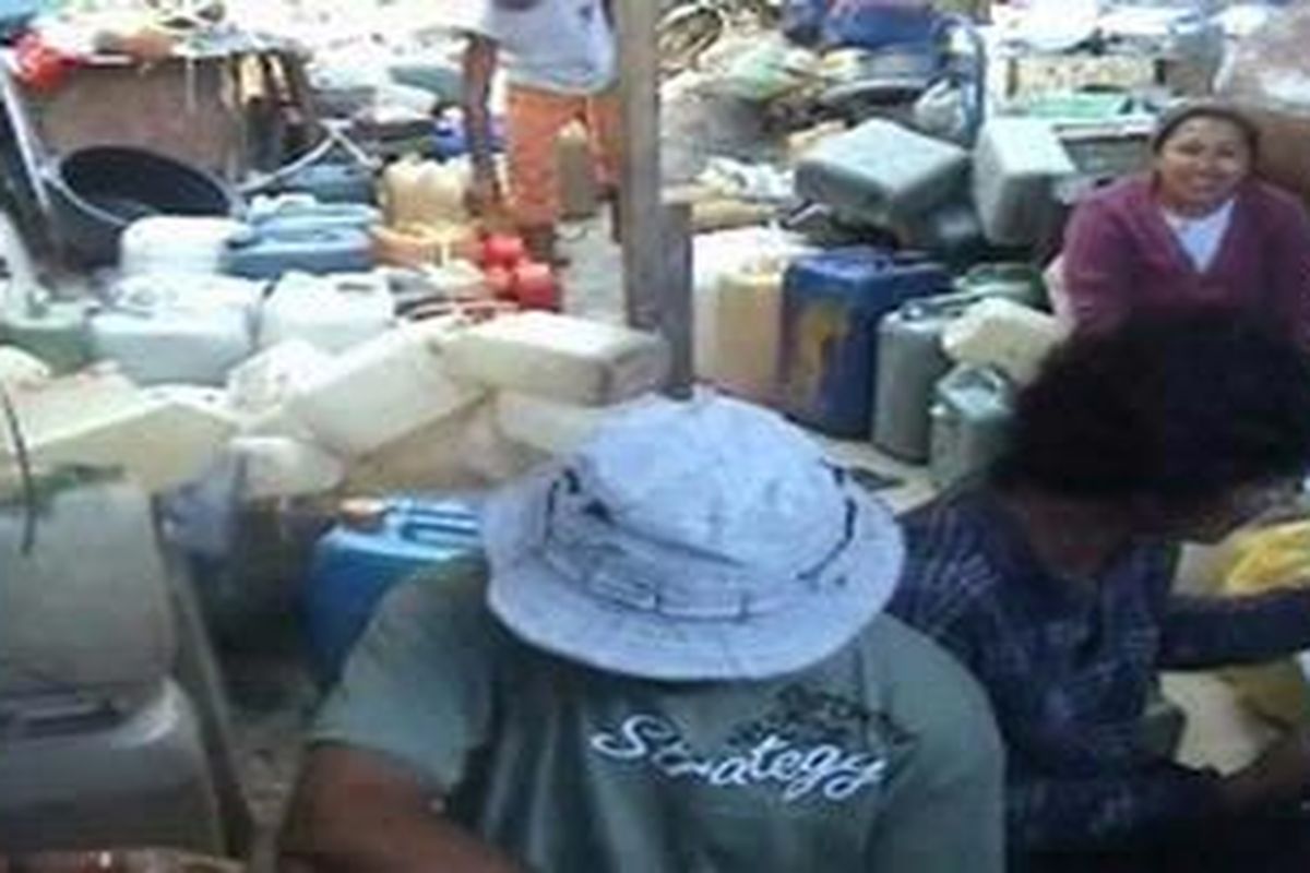 Berbekal jeriken, warga mengantre selama berjam-jam untuk mendapatkan lima liter minyak tanah.
