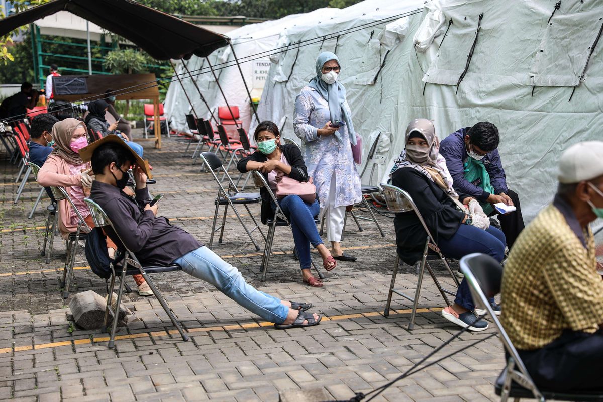 Warga duduk sambil menjaga jarak saat antre tes cepat pemeriksaan Covid-19 di Rumah Sakit Umum Daerah (RSUD) Pasar Minggu, Jakarta Selatan, Senin (6/4/2020). RSUD Pasar Minggu ditetapkan menjadi salah satu rumah sakit rujukan di Jakarta yang bisa melayani pasien dengan gejala terinfeksi, diduga terinfeksi, ataupun terinfeksi Covid-19.