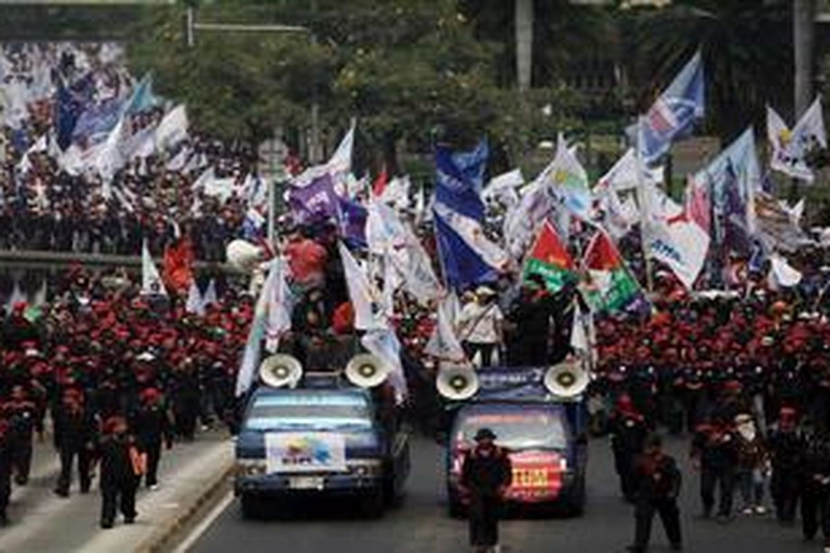 Ribuan buruh dari Konfederasi Serikat Pekerja Indonesia berjalan menuju Istana Merdeka, Jakarta untuk berunjuk rasa, Kamis (12/7/2012). Mereka memprotes peraturan menteri tenaga kerja yang mengatur pekerja kontrak (outsourching).