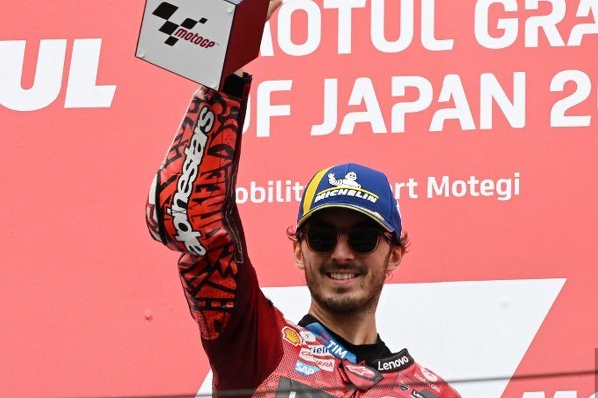 Pebalap Ducati Lenovo Team, Francesco Bagnaia, mengangkat trofi kemenangannya di podium pertama usai balapan MotoGP Jepang 2024 di Sirkuit Motegi, pada 6 Oktober 2024. (Photo by Toshifumi KITAMURA / AFP)