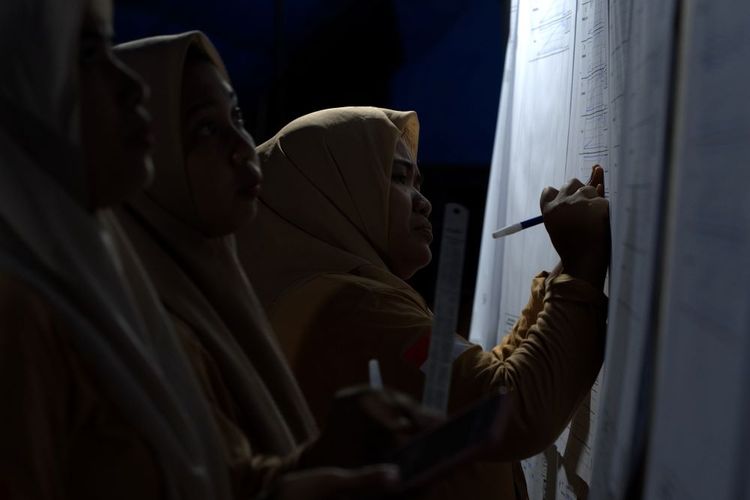 Anggota KPPS mencatat hasil perhitungan suara di Kelurahan Ranomeeto, Konawe Selatan, Sulawesi Tenggara, Kamis (15/2/2024). Perhitungan suara Pemilu 2024 dilakukan hingga dini hari dengan minimnya penerangan lampu. ANTARA FOTO/Jojon/rwa.