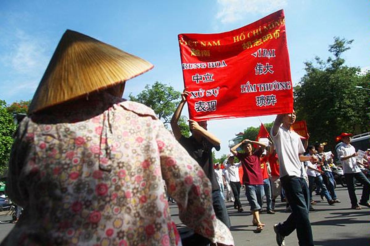 Para pemrotes  melakukan pawai dengan membawa spanduk bertuliskan China yang besar berperilaku buruk di Hanoi, Vietnam, Minggu (5/6).