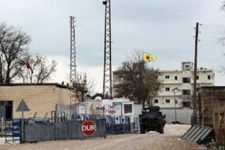 Salah satu sudut kota Kobani, Irak, yang sudah dikuasai satuan pelindung rakyat (YPG) Kurdi, yang mengibarkan bendera berwarna kuning dengan bintang berwarna merah di tengahnya. YPG penguasa kota Kobani setelah memukul mundur milisi NIIS. 
