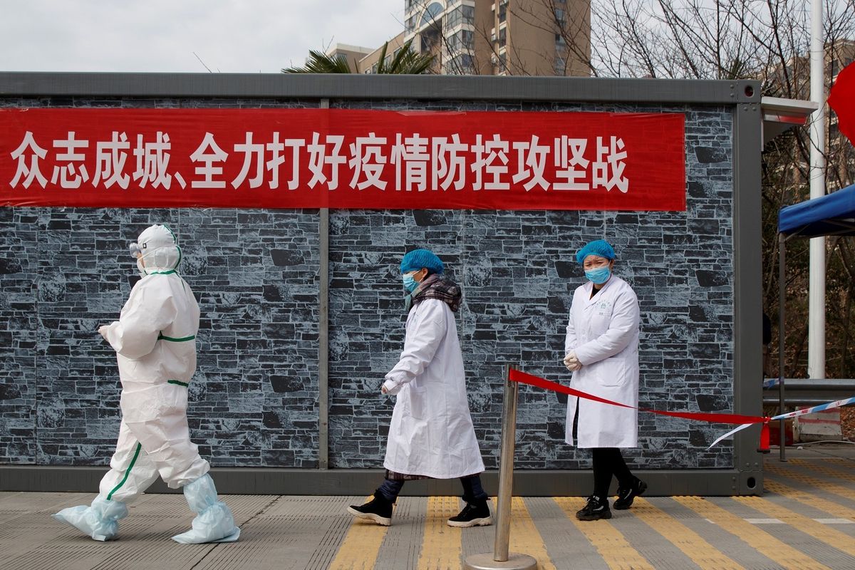 Staf medis dengan pakaian lengkap berjalan di pos pemeriksaan zona eksklusi Jembatan Sungai Yangtze di Jiujiang, Provinsi Hubei, pada 1 Februari 2020 di tengah merebaknya virus corona.