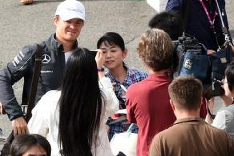 Pebalap Mercedes asal Jerman, Nico Rosberg (kiri), melayani para penggemar yang mengelilinya saat tiba di Sirkuit Suzuka, Jumat (3/10/2014).