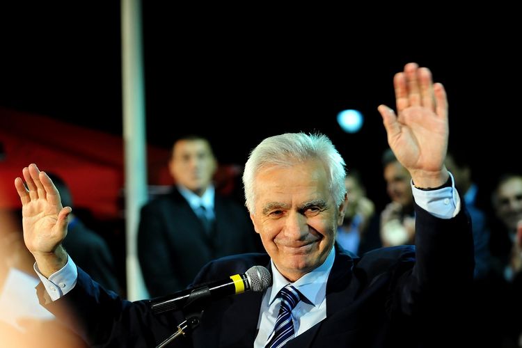 Politisi Serbia Bosnia Momcilo Krajisnik melambai ke kerumunan saat ia disambut kembali di kampung halamannya Pale pada 30 Agustus 2013. Krajisnik disambut oleh beberapa ribu orang setelah menjalani dua pertiga dari hukuman 20 tahun hukumannya karena kejahatan perang terhadap penduduk non-Serbia di Bosnia, selama perang 1992-95.