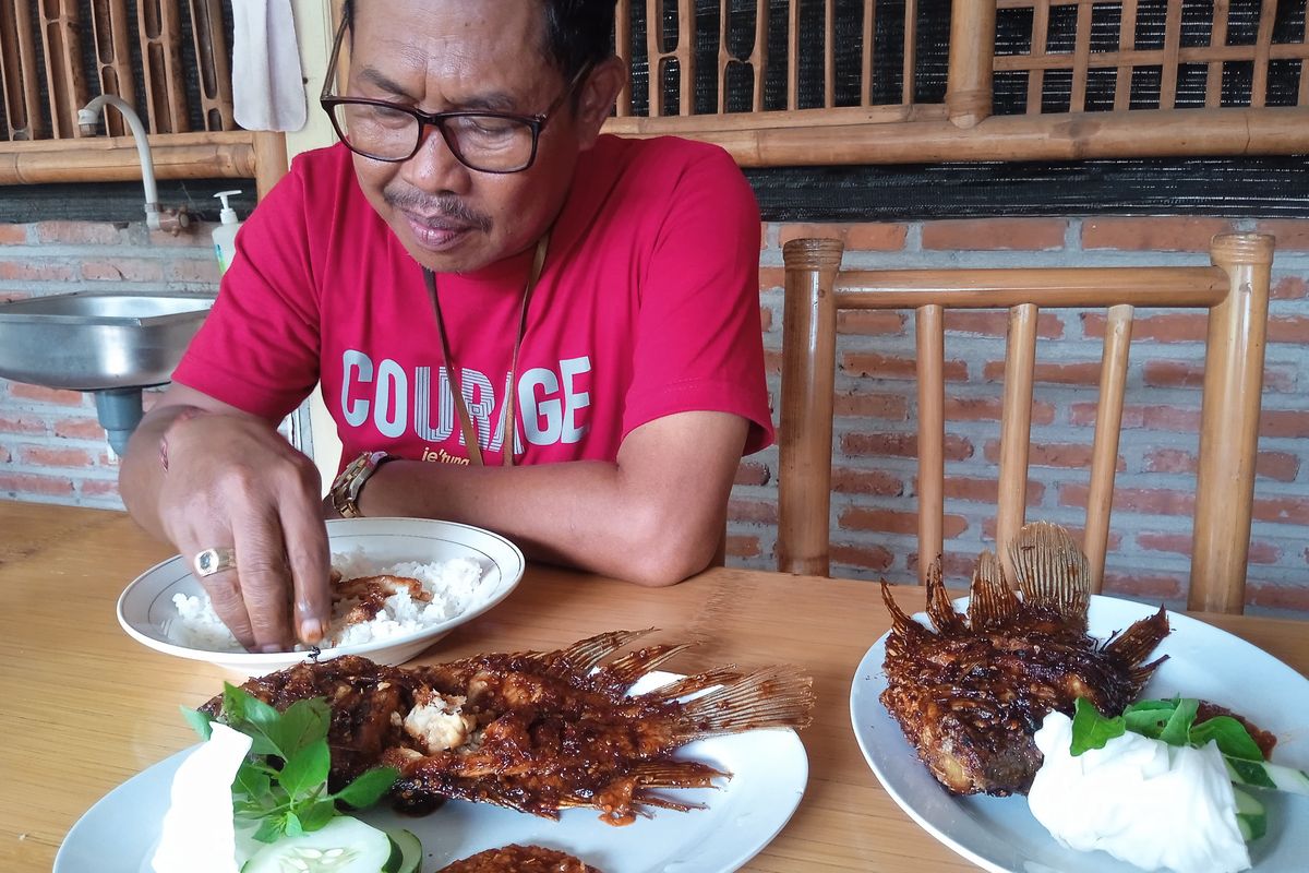 Salah satu pengunjung Lesehan Mewah Nganjuk, Suwandi (57), saat menyantap Gurami Bakar Pedas, Senin (13/1/2025).