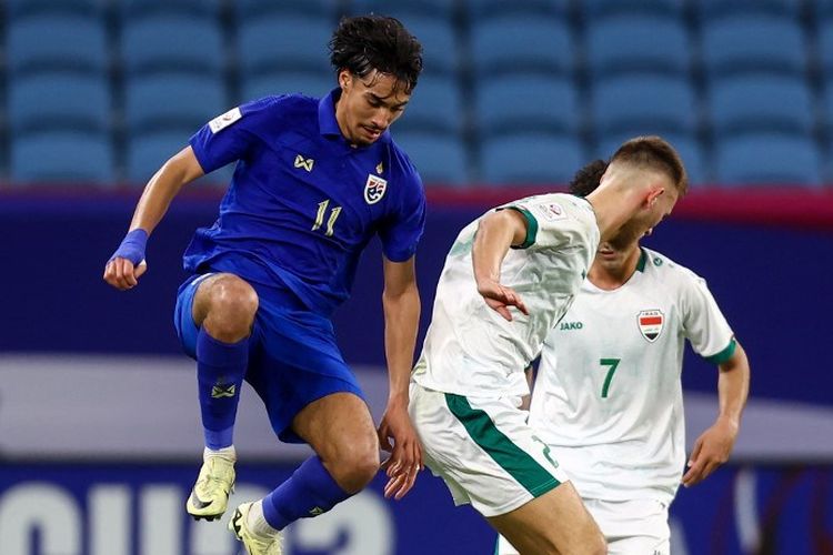 Aksi perebutan bola antara Irawan Garnier (11) dengan Karrara Mohammed dalam laga Piala Asia U23 2024 antara Irak vs Thailand di Stadion Al Janub, Doha, 16 April 2024. (Photo by KARIM JAAFAR / AFP)