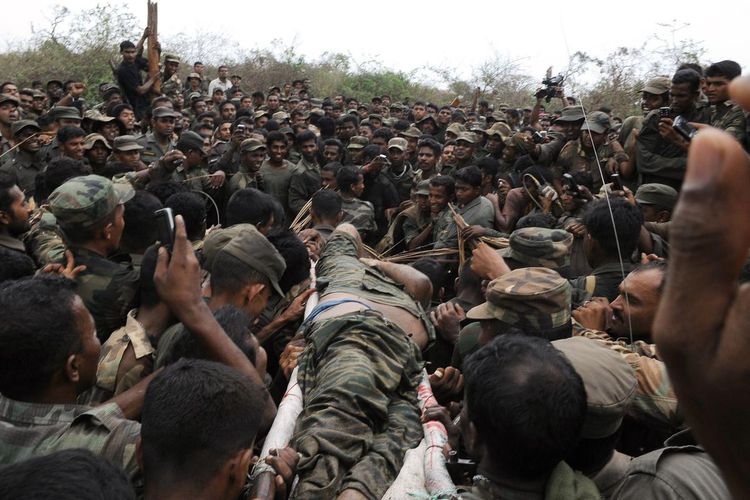 Tubuh pemimpin Pembebasan Macan Tamil Eelam (LTTE) Vellupillai Prabhakaran dibawa dengan tandu melalui sekelompok tentara di Sri Lanka utara saat Perang Saudara Sri Lanka pada 19 Mei 2009.