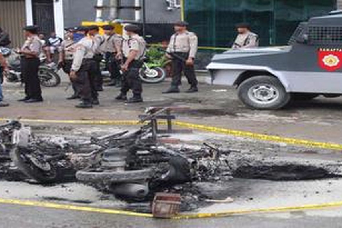 Polisi berjaga-jaga di sekitar kawasan Perumnas III Waena, Kota Jayapura. Amuk massa menyusul penangkapan aktivis Papua Mako Tabuni, Kamis (14/6/2012) itu membuat sedikitnya empat warga terluka, empat mobil dan 24 sepeda motor hangus terbakar.  