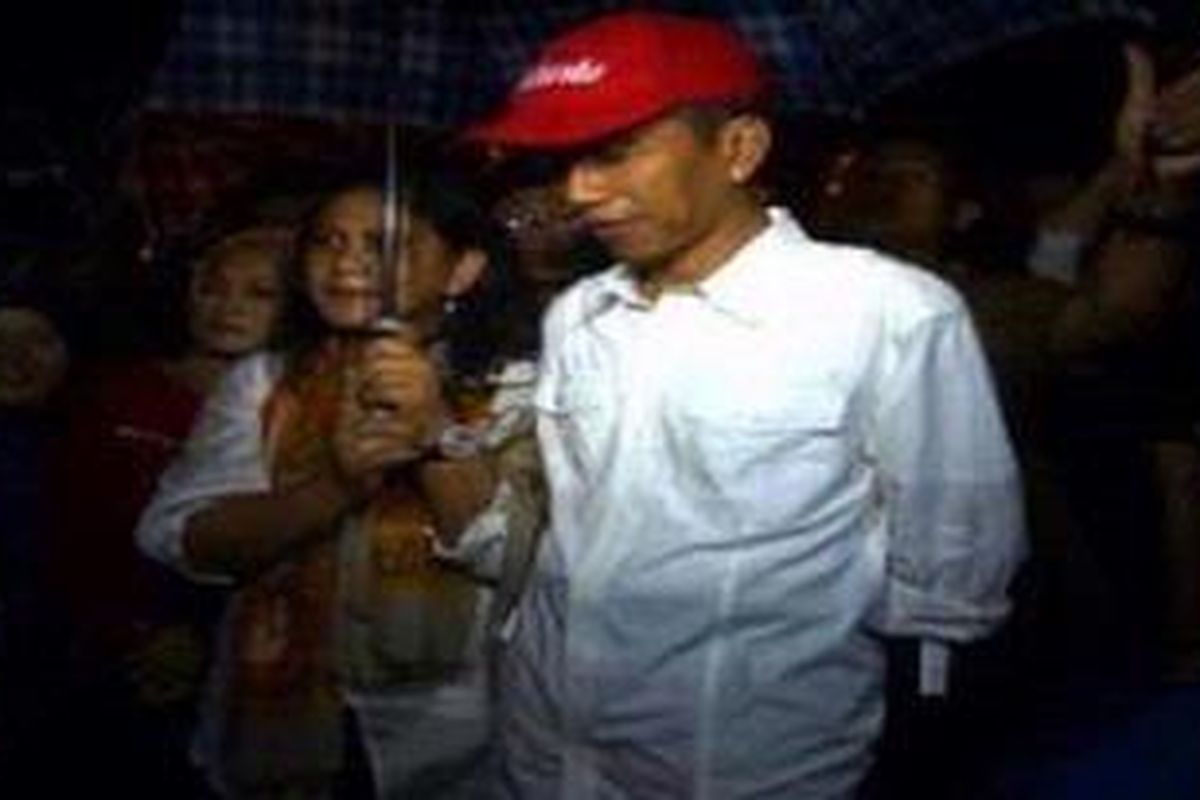 Gubernur DKI Jakarta Joko Widodo bersama istrinya, Iriana Widodo mengecek lokasi banjir di Pejaten Timur, Pasar Minggu, Jakarta Selatan, Selasa (15/1/2013) malam. Di sana Jokowi langsung menyerahkan bantuan berupa uang, beras, dan lauk pauk kepada warga yang menjadi korban pengungsian.