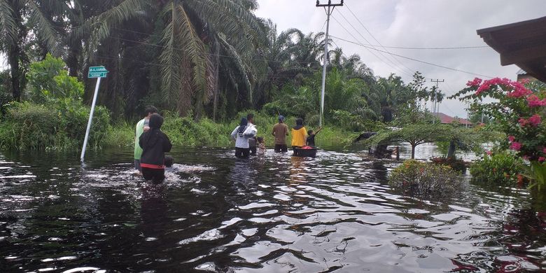 Warga mengarungi banjir untuk melihat kondisi rumahnya di Kelurahan Bumi Ayu, Kecamatan Dumai Selatan, Kota Dumai, Riau, Sabtu (30/10/2021).