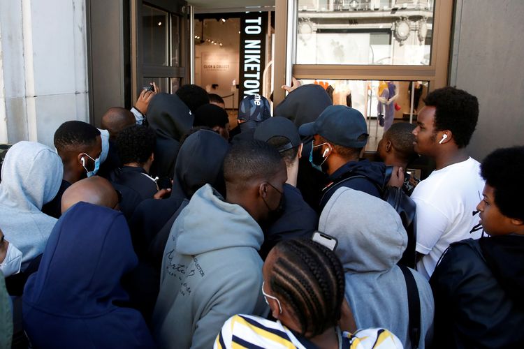 Para pengunjung saling dorong saat memasuki Nike Town yang dibuka lagi usai lockdown, Senin (15/6/2020). Toko ini berlokasi di Oxford Street, London, Inggris.