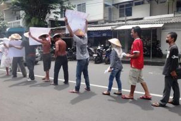 Pegiat anti korupsi di Jember, Jawa Timur, Sabtu (24/1/2015), berjalan mundur sebagai bentuk kekecewaan terhadap Presiden Jokowi, yang dinilai tidak tegas menyikapi konflik KPK- Polri.