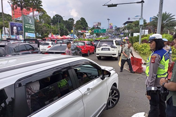 Anggota Satlantas Polres Bogor, Aipda Desi Apriyanti saat mengurai kepadatan arus kendaraan dari arah Jakarta di pintu keluar tol Ciawi Simpang Gadog, Puncak Bogor, pada Senin (24/4/2023) pukul 14.00 WIB.