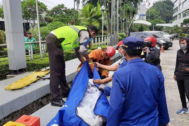 Petugas mengevakuasi korban tewas akibat kecelakaan dua bus transjakarta di Halte Cawang-Ciliwung, Jakarta Timur, Senin (25/10/2021) pagi.