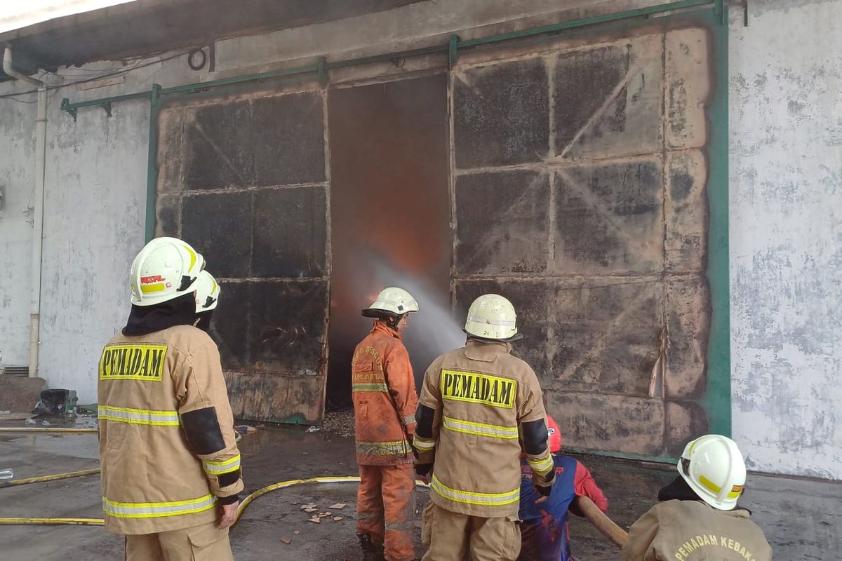 Petugas padamkan api yang merembet ke gudang kawasan  Kapuk Muara, Penjaringan, Jakarta Utara, Minggu (30/7/2023).