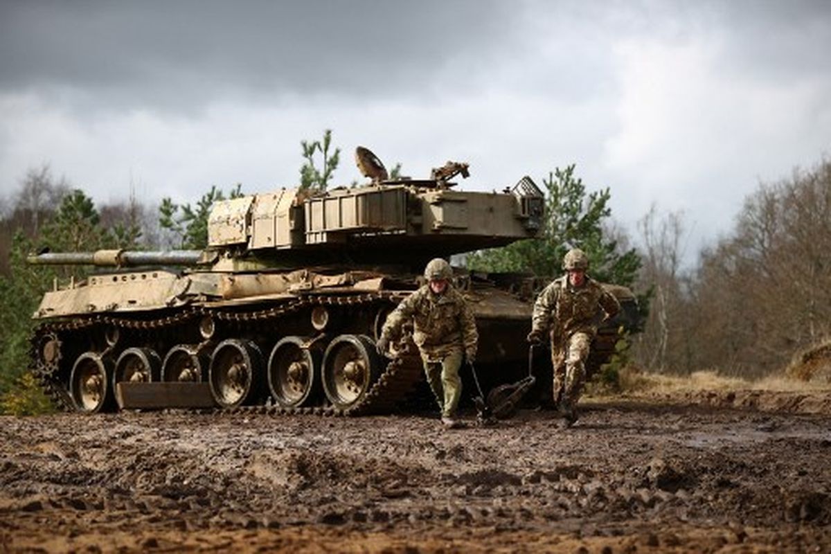 Tentara membawa alat bantu untuk menarik tank tempur dari parit tergenang air dan mendaki bukit selama Latihan Royal Electrical & Mechanical Engineers yang disebut Iron Challenge di area pelatihan Longmoor, dekat Bordon, Hampshire, pada 14 Maret 2022.