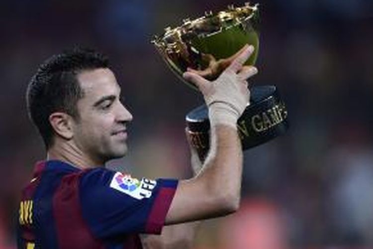 Gelandang Barcelona, Xavi Hernandez, mengangkat trofi Joan Gamper, pada Senin (18/8/2014). Barcelona menjuarai laga persahabatan itu setelah menang 6-0 Leon, di Camp Nou, Senin (18/8/2014).
