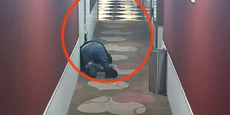 Dalam potongan rekaman kamera CCTV, seorang pria di China bernama He nampak berjongkok di depan kamar hotel dan mendengarkan pasangan berhubungan seks di dalamnya.
