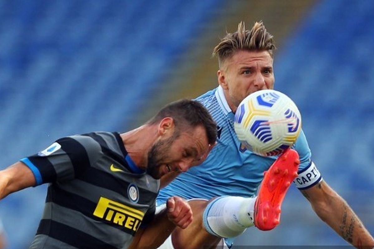 Stefan De Vrij (kiri) berduel dengan Ciro Immobile dalam laga Lazio vs Inter Milan di Stadion Olimpico, Minggu (4/10/2020), pada lanjutan Serie A - kasta tertinggi Liga Italia.