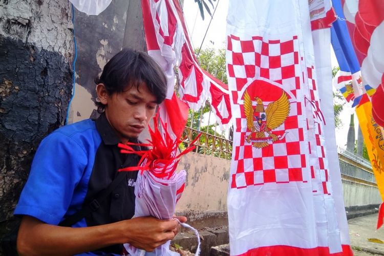 Uus merapikan bendera dagangannya di Jalan Merdeka Utama, Kota Lhokseumawe, Jumat (4/8/2017)