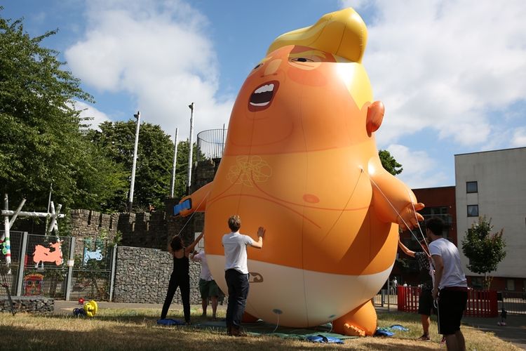 Sejumlah aktivis menyiapkan balon raksasa berbentuk bayi Trump yang akan diterbangkan di samping gedung parlemen Inggris pada Jumat (13/7/2018).