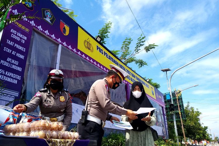 Polisi lalu lintas Polres Blitar memberikan sertifikat vaksin dan paket bantuan telur kepada warga pengguna jalan yang terjaring operasi dan bersedia disuntik vaksin di Pos Pengamanan Natal dan Tahun Baru di Kanigoro, Kabupaten Blitar, Jumat (24/12/2021)