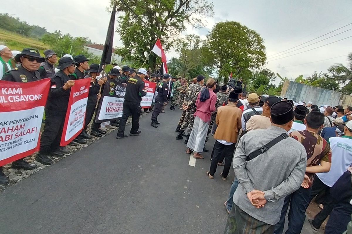 Para ulama, santri dan tokoh masyarakat Kecamatan Cisayong, Kabupaten Tasikmalaya, Jawa Barat, turun ke jalan berunjukrasa menolak pesantren yang diduga tak sesuai Ahlus Sunnah Waljamaah sesuai dengan yang dianut mayoritas wilayah itu di Kampung Neundeut, Cisayong, Jumat (3/2/2023).