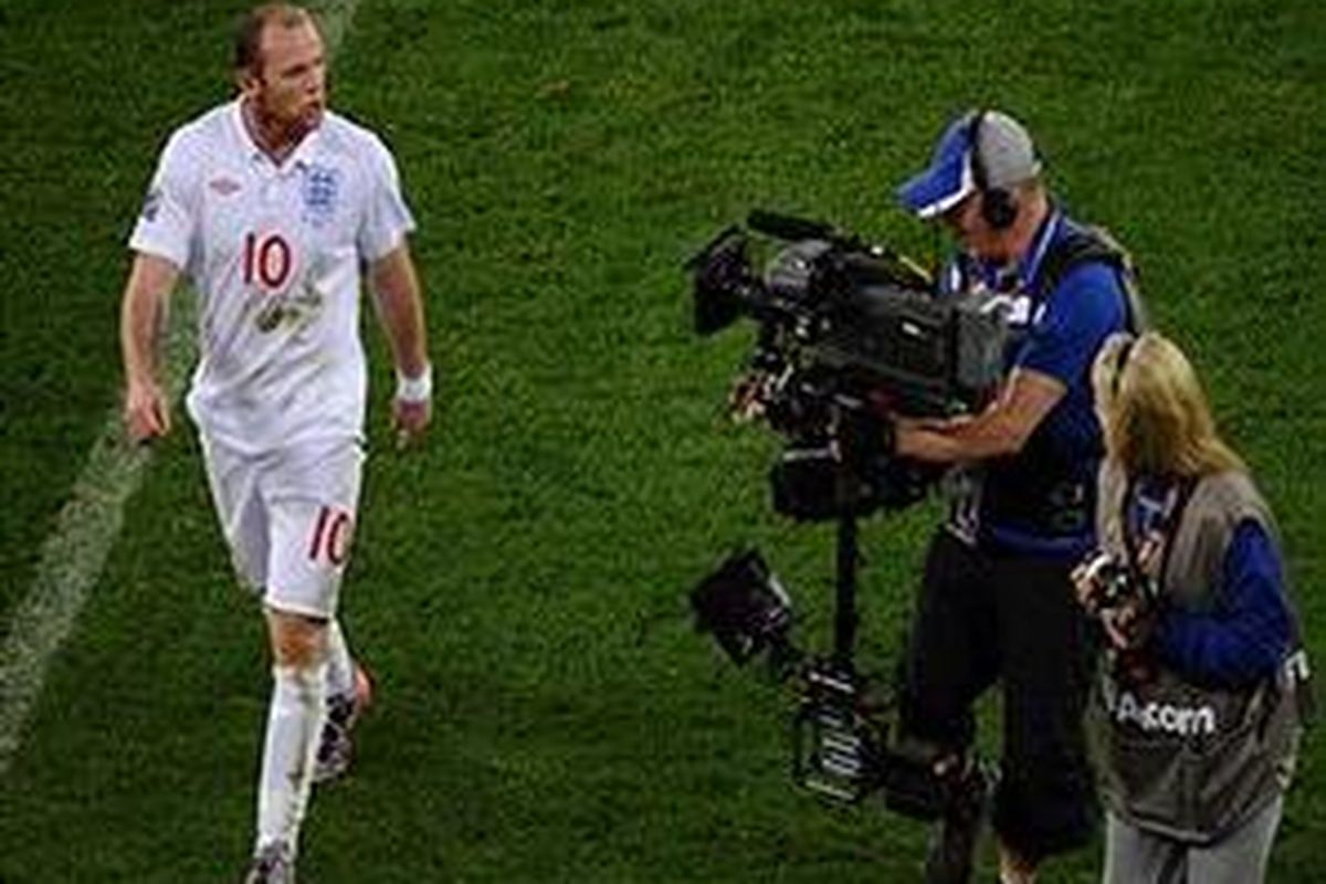 Striker Inggris Wayne Rooney (kiri) berbicara di depan kamera saat meninggalkan lapangan usai pertandingan lawan Aljazair pada penyisihan Grup C Piala Dunia 2010, Jumat (18/6/2010).
