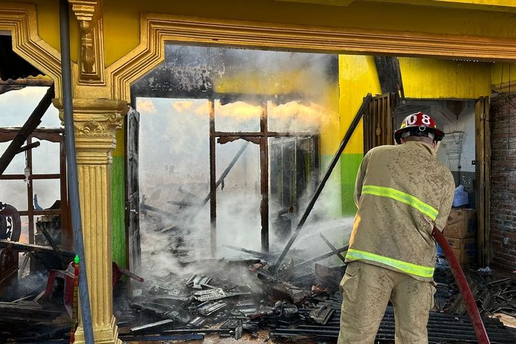 Petugas Satpol PPK Trenggalek, melakukan upaya pemadaman api di rumah salah satu warga Kecamatan Gandusari Trenggalek Jawa Timur yang terbakar, Selasa (19/03/2024)