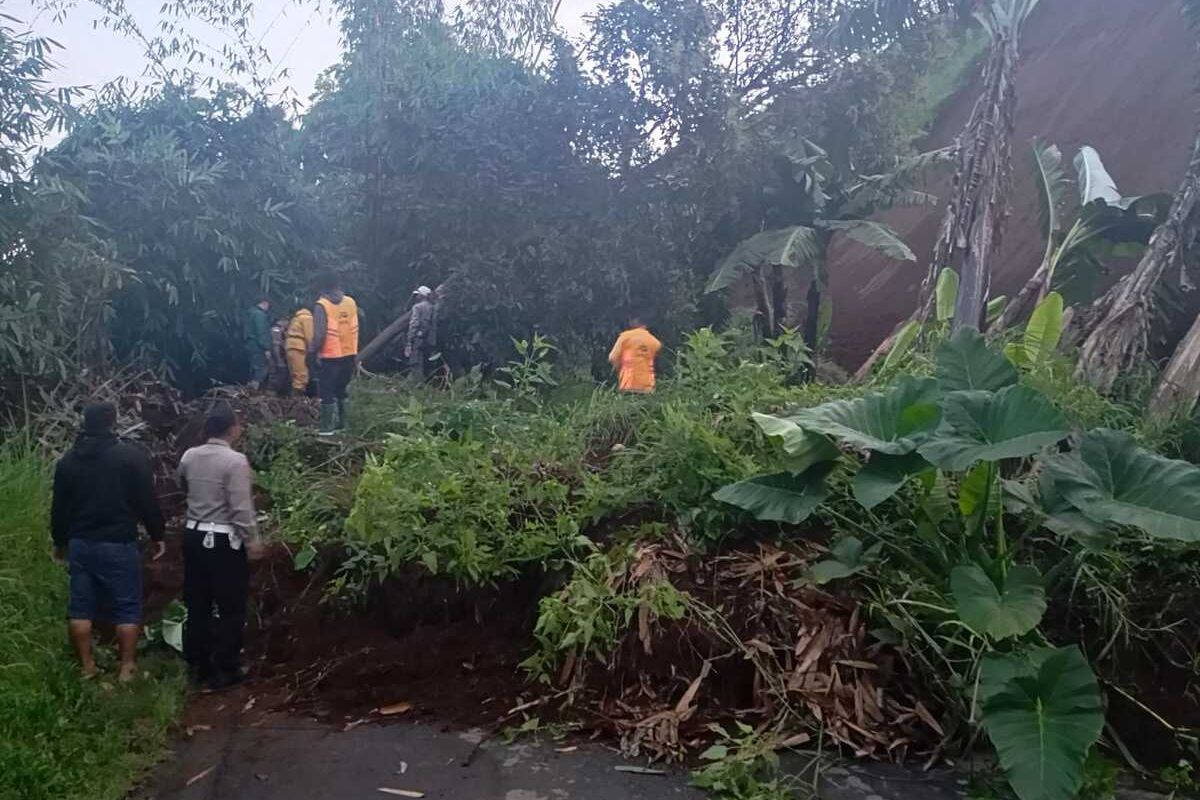 Sejumlah petugas dan warga tengah membersihkan material longsor yang sempat menutup akses Jalan Raya Pangalengan, Kabupaten Bandung, Jawa Barat, Senin (14/4/2025) pagi tadi
