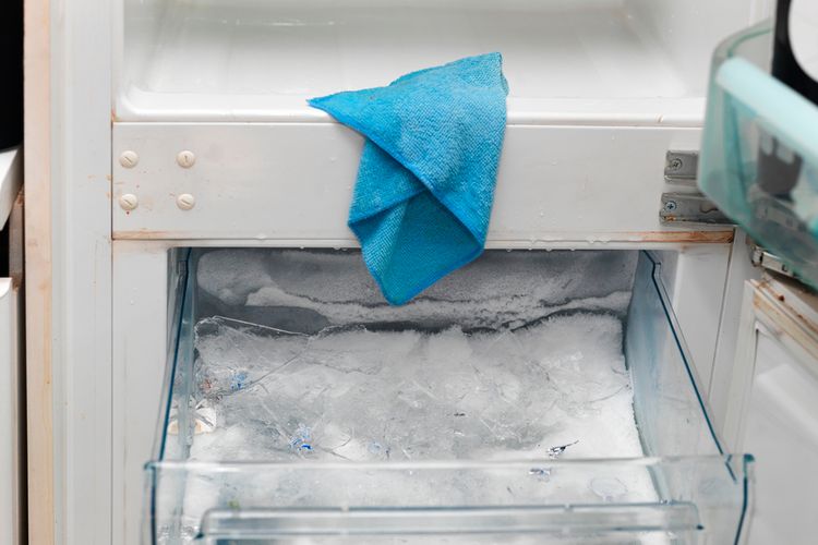 Ilustrasi membersihkan bunga es freezer menggunakan kain panas ditetesi alkohol gosok. 