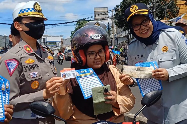 Seorang siswi Sekolah Menengah Atas (SMA) saat menunjukkan SIM dan STNK nya saat Satlantas Polres Metro Jakarta Selatan menggelar Operasi Keselamatan Jaya 2024 di persimpangan Pasar Minggu, Jakarta Selatan, Rabu (6/3/2024).