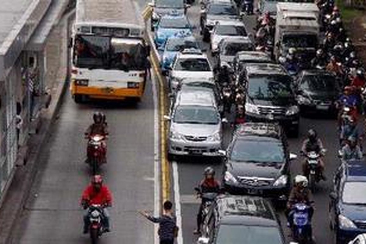 Seorang calon penumpang tampak menyetop bus angkutan umum di jalur busway koridor IX, Jalan Gatot Subroto, Jakarta, Jumat (7/1/2011). 