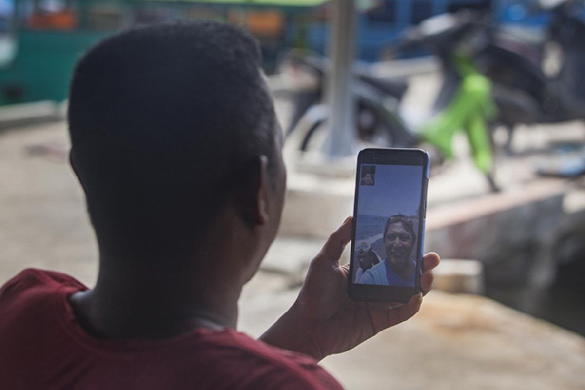 Heriman (42), seorang pengepul ikan tangkapan nelayan mengakses internet menggunakan gawai  di Teluk Baruk, Sepempang, Natuna, Selasa, 8 Oktober 2019.  