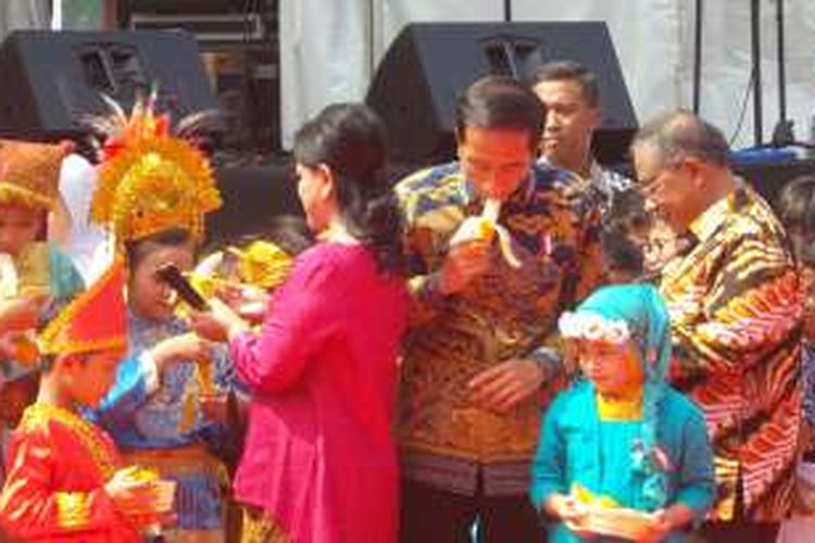 Presiden Joko Widodo memakan pisang dalam acara Fruits Indonesia 2016 di Lapangan Parkir Timur Senayan Jakarta Kamis (17/11/2016)