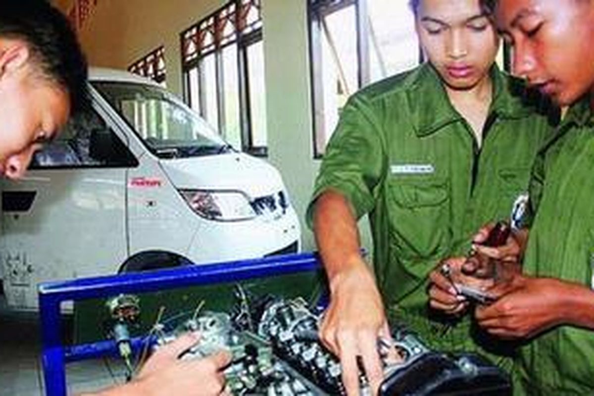 Siswa Jurusan Otomotif Sekolah Menengah Kejuruan Negeri (SMKN) 2 Surakarta praktik penyetelan katup mesin mobil beberapa waktu lalu. Di latar belakang tampak mobil Esemka Rajawali Bima yang merupakan minitruk hasil rakitan para siswa SMK ini.