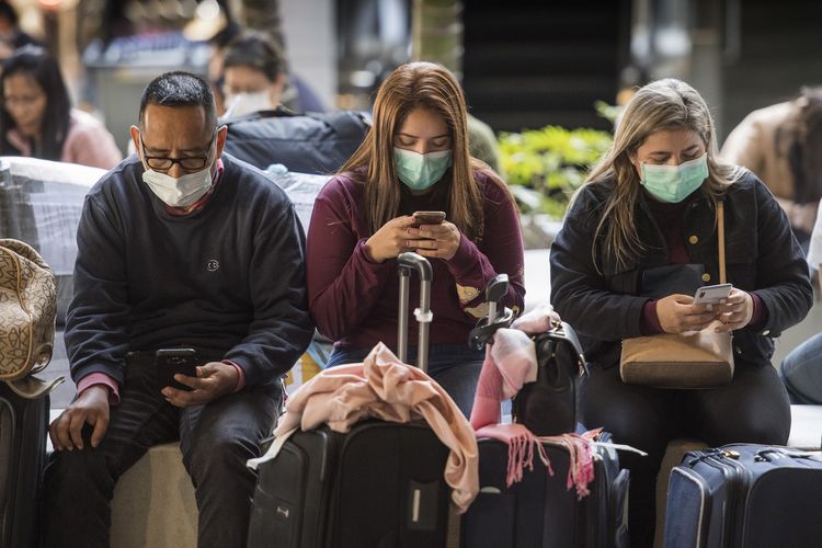 Penumpang pesawat mengenakan masker untuk mencegah tertular virus corona saat tiba di Bandara International Los Angeles, Amerika Serikat.