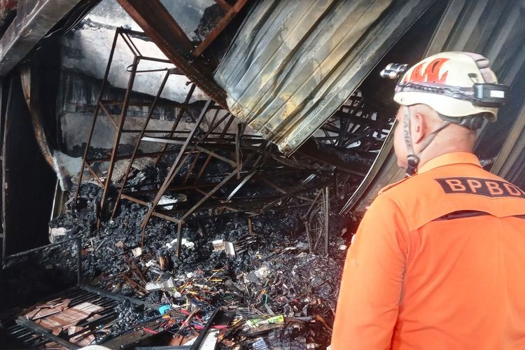 Seorang petugas BPBD menjaga lokasi kebakaran yang meluluhlantakkan toko bangunan di Kabupaten Cianjur, Jawa Barat. Akibat keristiwa ini tiga orang pegawai toko tewas terpanggang.