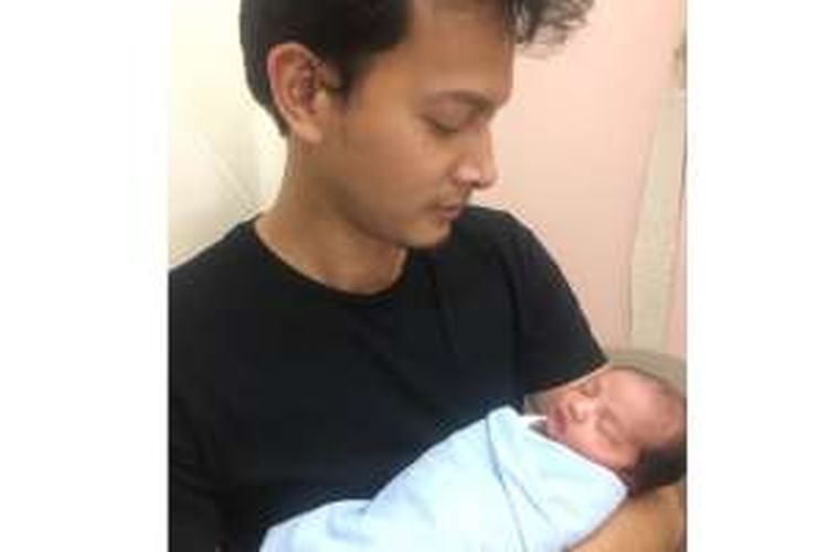 Fedi Nuril menggendong putranya yang baru lahir, Hasan Fadilah Nuril, di Rumah Sakit Pondok Indah (RSPI), Jakarta Selatan, pada Jumat (9/12/2016).