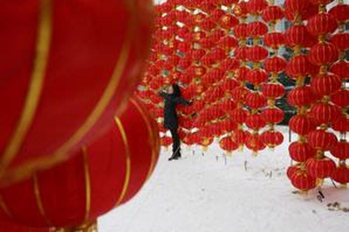 Seorang perempuan berfoto di depan lampion menjelang Imlek di Hubei, Sabtu (26/1).
