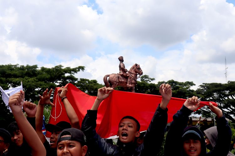 Suporter Arema, Aremania dan masyarakat bernyanyi bersama saat melakukan aksi damai terkait Tragedi Kanjuruhan untuk menuntut keadilan yang dilaksanakan serentak di sejumlah titik Kota Malang, Minggu (27/11/2022) siang.