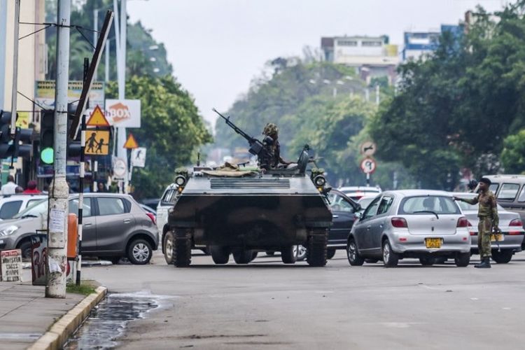 Tentara Zimbabwe dengan sebuah kendaraan lapis baja berjaga di sebuah perempatan jalan di ibu kota Harare, Rabu (15/11/2017).