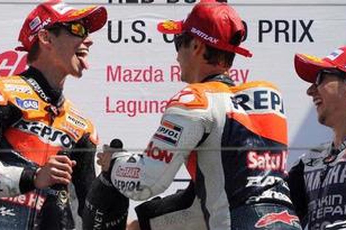 Pebalap Repsol Honda, Casey Stoner (kiri), mendapat sambutan dari rekan setimnya, Dani Pedrosa, serta pebalap Yamaha, Jorge Lorenzo (kanan), usai GP Amerika Serikat, Minggu (29/7/2012). Stoner jadi pemenang seri ke-10 ini, disusul Lorenzo dan Pedrosa.