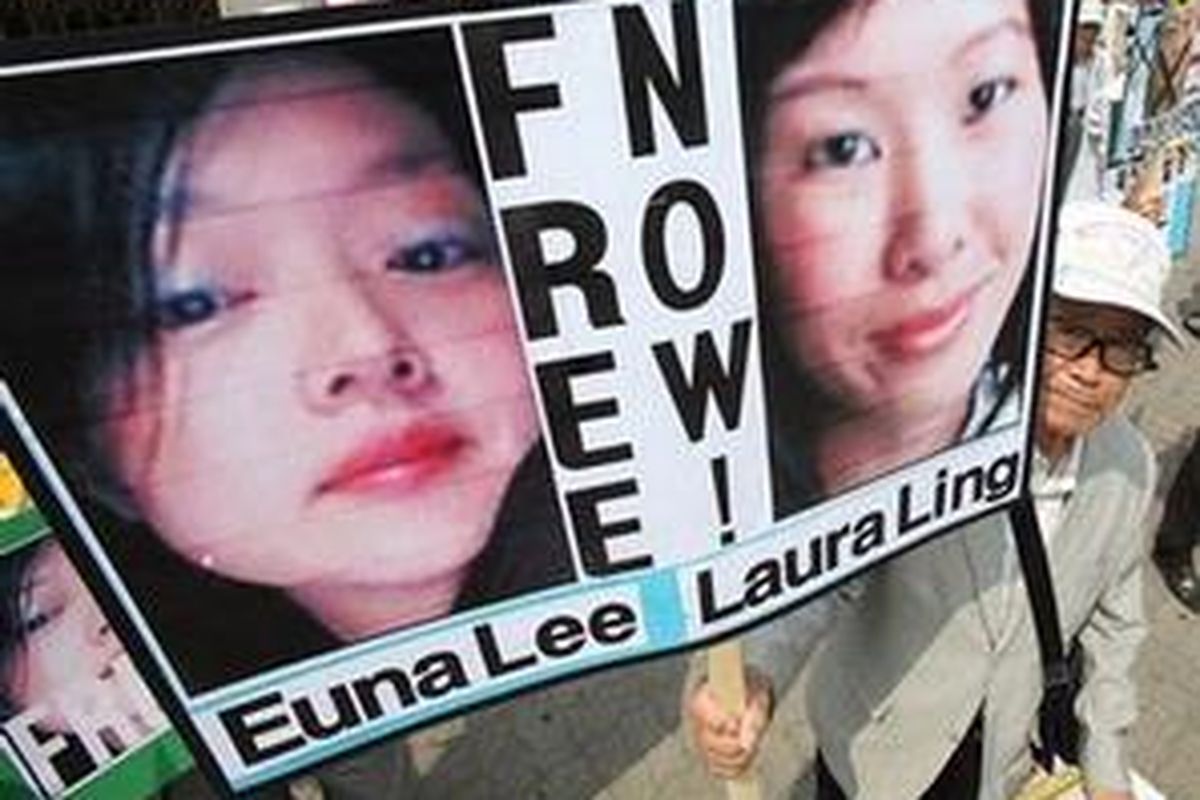 Seorang demonstran Korea Selatan menunjukkan poster 2 wartawati AS yang ditahan oleh Pyongyang saat berlangsung unjuk rasa anti-Korea Utara di Seoul, 4 Juni 2009 